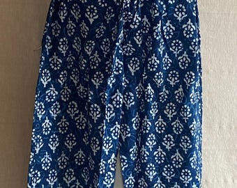 May include: Blue and white patterned pants. The pants have a wide leg and a repeating floral design. The pants are made of a lightweight fabric and appear to be comfortable.