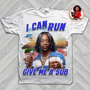 Puede incluir: Camiseta blanca con un gráfico de un hombre con un chándal azul y blanco que sostiene un micrófono y un vaso de líquido. El texto "I CAN RUN GIVE ME A SUB" está impreso en azul en la camiseta.