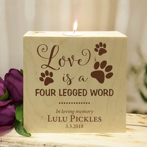 May include: Wooden candle holder with the text "Love is a four legged word" and paw prints. The text "In loving memory Lulu Pickles 3.3.2018" is also engraved on the holder.