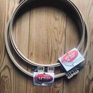 May include: Two embroidery hoops, one 12 inch and one 14 inch, both beige in color. The hoops are labeled "Morgan No-Slip Hoop".