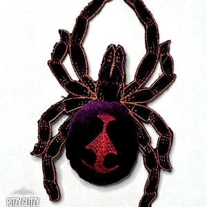 May include: Black velvet spider patch with an orange outline and a red and black velvet abdomen.
