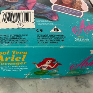Pode incluir: Uma caixa azul e verde com uma imagem de Ariel de A Pequena Sereia na frente. A caixa diz "Cool Teen Ariel Teenager" e "Undersea Teenage Fun!" A caixa &eacute; para uma boneca ou um brinquedo.