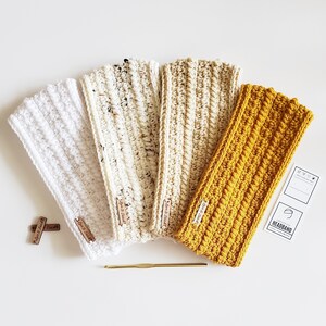 May include: Four crocheted headbands in white, cream, beige, and mustard yellow. The headbands are made with a textured stitch and have a simple, minimalist design.