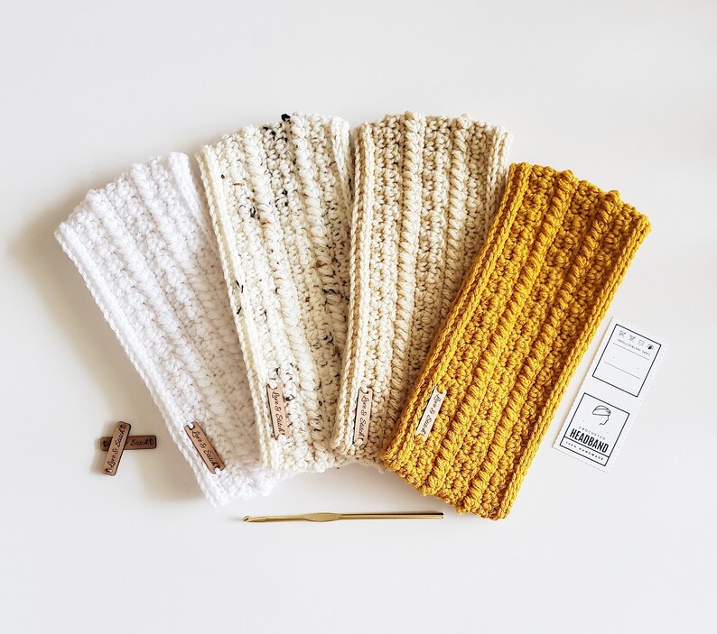 May include: Four crocheted headbands in white, cream, beige, and mustard yellow. The headbands are made with a textured stitch and have a simple, minimalist design.