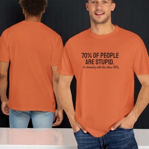 May include: A burnt orange short-sleeved t-shirt featuring the black text 70% OF PEOPLE ARE STUPID. I'm obviously with the other 40%. The shirt is shown from both the front and the back, displaying a plain orange back and a graphic front.