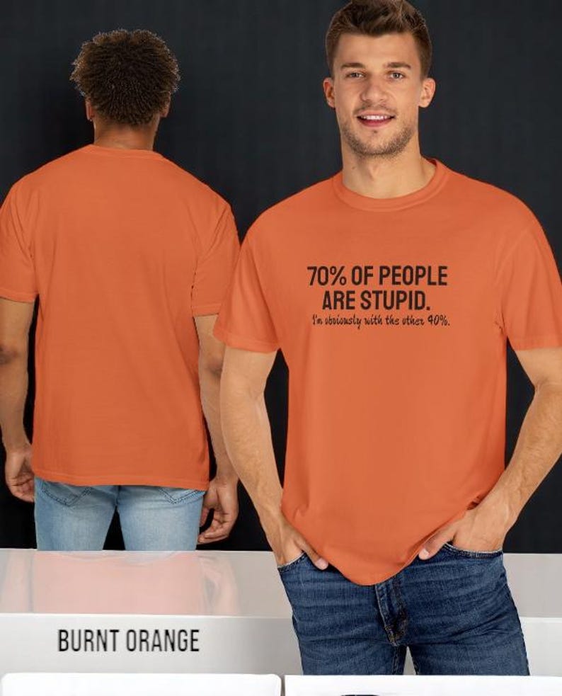 May include: A burnt orange short-sleeved t-shirt featuring the black text 70% OF PEOPLE ARE STUPID. I'm obviously with the other 40%. The shirt is shown from both the front and the back, displaying a plain orange back and a graphic front.