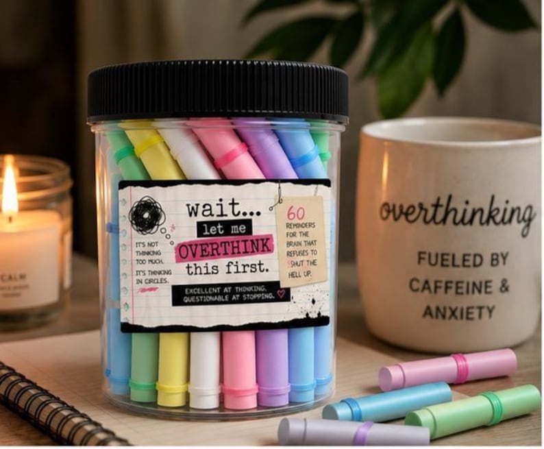 May include: A clear plastic jar with a black lid containing 60 pastel-colored paper scrolls. The label reads: wait... let me OVERTHINK THIS FIRST. It's not thinking too much, it's thinking in circles. 60 reminders for the brain that refuses to shut the hell up. Excellent at thinking, questionable at stopping.