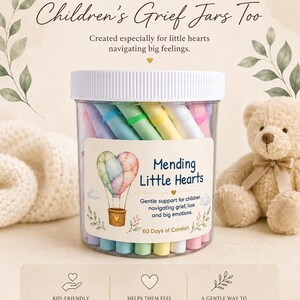 May include: A clear plastic jar filled with pastel-colored paper scrolls. The label features a watercolor hot air balloon heart, the text Mending Little Hearts, and the phrase 60 Days of Comfort. The jar has a white lid and contains affirmations.