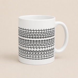 May include: A white ceramic mug featuring a repeating black graphic pattern of horizontal bands. The design consists of alternating rows of stylized wave motifs, thin lines, and small circular loops encircling the exterior of the mug.