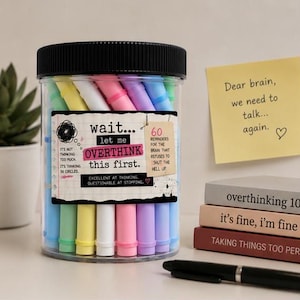 May include: A clear plastic jar with a black lid filled with pastel-colored markers. The label reads: wait... let me OVERTHINK this first. It's not thinking too much. It's thinking in circles. 60 reminders for the brain that refuses to shut the hell up.