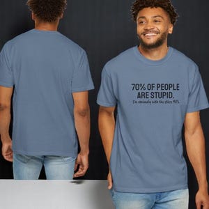 May include: A blue jean colored short-sleeve t-shirt featuring the black printed text 70% OF PEOPLE ARE STUPID. I'm obviously with the other 40%. The shirt is shown from both the front and back views, displaying a crew neckline and a standard fit.