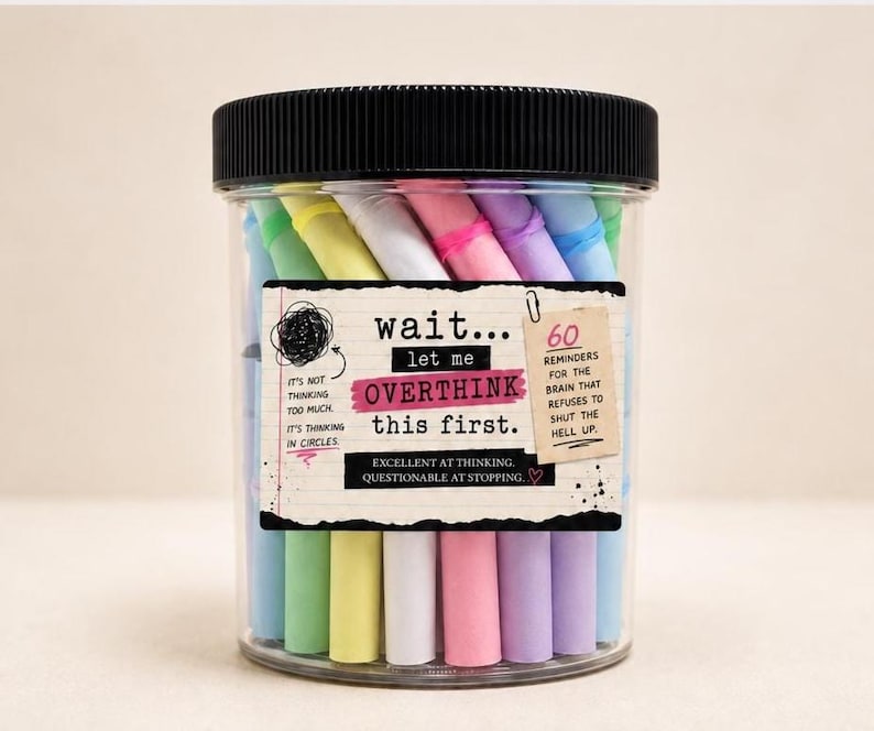 May include: A clear plastic jar with a black lid containing 60 colorful paper scrolls. The label reads: wait... let me OVERTHINK this first. It's not thinking too much. It's thinking in circles. 60 reminders for the brain that refuses to shut the hell up. Excellent at thinking. Questionable at stopping.