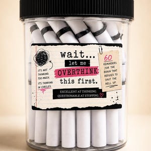 May include: A clear plastic jar with a black lid filled with white paper scrolls. The label reads: wait... let me OVERTHINK this first. It includes text about thinking in circles, 60 reminders for the brain, and excellent at thinking, questionable at stopping.