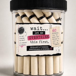 May include: A clear plastic jar with a black lid containing rolled paper scrolls secured with black rings. The label reads: wait... let me OVERTHINK this first. It's not thinking too much. It's thinking in circles. 60 REMINDERS FOR THE BRAIN THAT REFUSES TO SHUT THE HELL UP. EXCELLENT AT THINKING. QUESTIONABLE AT STOPPING.