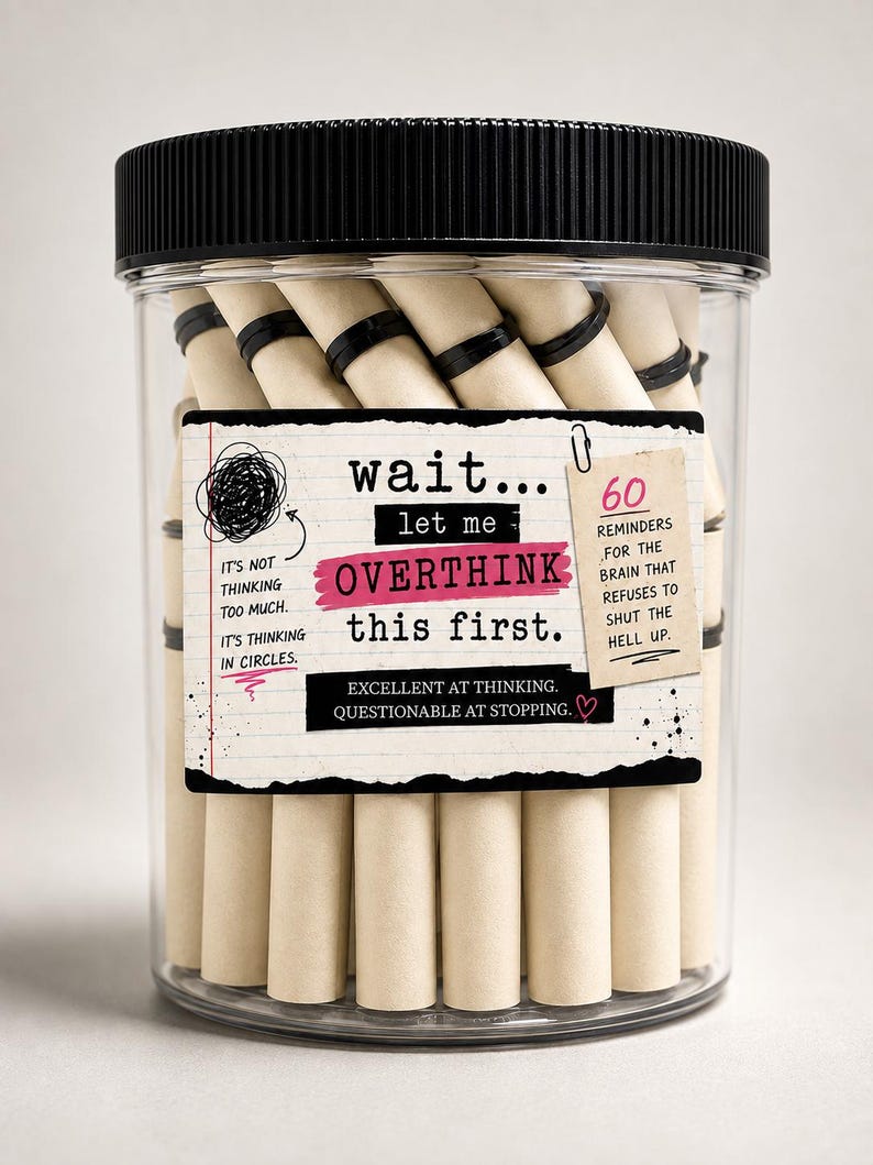 May include: A clear plastic jar with a black lid containing rolled paper scrolls secured with black rings. The label reads: wait... let me OVERTHINK this first. It's not thinking too much. It's thinking in circles. 60 REMINDERS FOR THE BRAIN THAT REFUSES TO SHUT THE HELL UP. EXCELLENT AT THINKING. QUESTIONABLE AT STOPPING.