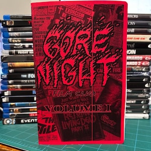 May include: A red and black "Gore Night Film Club Volume I" book cover. The cover features the title in a stylized font with a flame-like design. The background includes various movie titles and text.