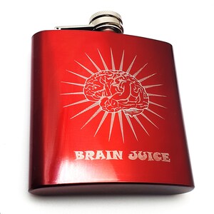 Könnte beinhalten: Rote Metallflasche mit silbernem Verschluss und einem gravierten Bild eines Gehirns mit dem Text "Brain Juice".