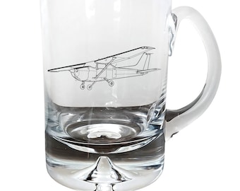 May include: A clear glass mug with a handle, featuring a line drawing of a small airplane on the front.