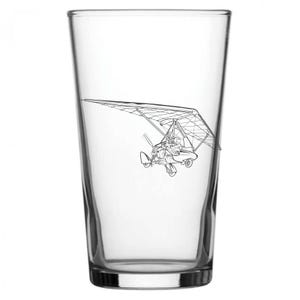 May include: A clear pint glass with a black and white line drawing of a hang glider. The hang glider is in flight, with the pilot visible. The glass is empty and has a simple, classic design.