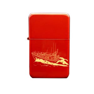 May include: Red metal lighter with a gold outline of a lifeboat on the front.