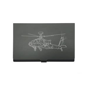 May include: A black business card holder featuring a white line drawing of a helicopter. The helicopter design is detailed, showing the rotor blades, body, and tail. The card holder is rectangular with a curved bottom.