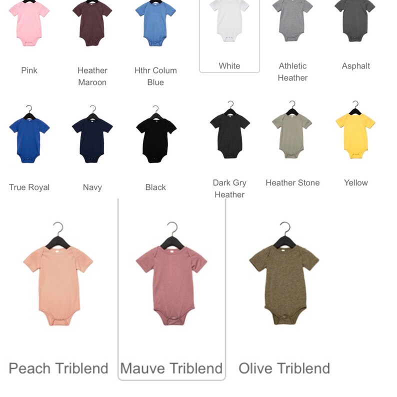 以下が含まれることがあります： ピンク、白、青、黒など、さまざまな色のベビーボディスーツが黒いハンガーに掛けられています。「Peach Triblend」や「Olive Triblend」など、色のオプションには名前が付けられています。