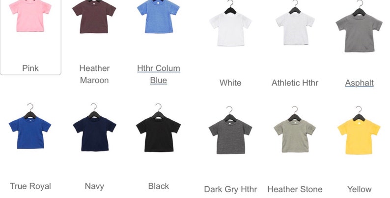 以下が含まれることがあります： ピンク、ブルー、ホワイト、ブラックなど、さまざまな色の半袖Tシャツのセレクション。黒いハンガーに掛けられています。各シャツの下に色の名前がラベル付けされています。これらのシャツはおそらく子供または幼児用です。