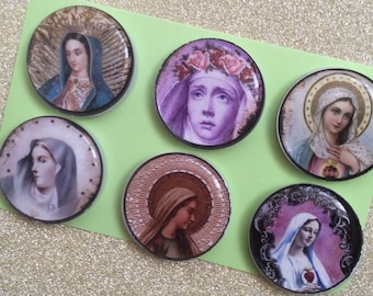 Könnte beinhalten: Sechs runde Buttons mit religiösen Bildern der Jungfrau Maria. Jeder Button zeigt ein anderes Bild, mit Farb- und Stilvariationen, vor einem hellgrünen Hintergrund.