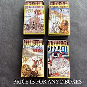 May include: Four vintage matchboxes with circus-themed illustrations. The boxes feature images of lions, performers, and text in various fonts. The text includes "LES LIONS DU JOUVEAU CIRO", "HIPPODROM NERO", and "CIRQUE ET". The matchsticks are visible.