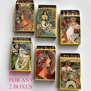 Può includere: Sei scatole di fiammiferi gialle con illustrazioni in stile Art Nouveau di donne con capelli lunghi e motivi floreali. Ogni scatola contiene fiammiferi marroni. Il testo "LA PLUME" e "Biscuits Lefevre Utile" è visibile su alcune scatole.