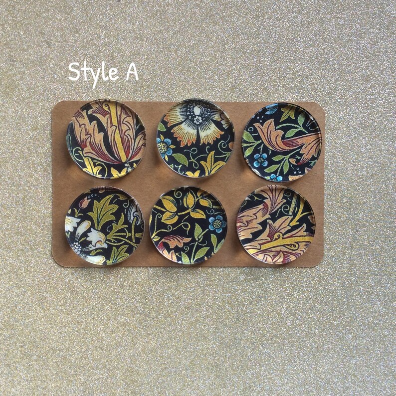 Puede incluir: Seis imanes redondos con patrones florales en blanco y negro. Los imanes est&aacute;n dispuestos en dos filas de tres sobre un fondo marr&oacute;n. El texto "Style A" est&aacute; impreso sobre los imanes.