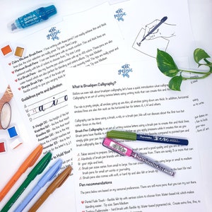 May include: A close-up of a guide to brush pen calligraphy, with a variety of brush pens laid out on a white surface. The guide includes information on brush pen calligraphy, guidelines for letter formation, and recommendations for different brush pen brands.
