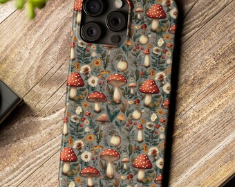 Könnte beinhalten: Handyhülle mit einem Muster aus roten, weiß gepunkteten Pilzen, Blumen und Blättern auf grauem Hintergrund. Das Design wiederholt sich über die gesamte Oberfläche der Hülle, die für ein Smartphone konzipiert ist.
