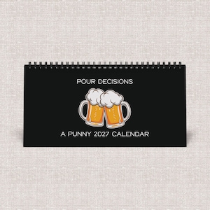 May include: A black spiral-bound desk calendar with the text POUR DECISIONS and A PUNNY 2027 CALENDAR printed in white. The center features a graphic illustration of two beer mugs clinking together, filled with golden liquid and white foam.