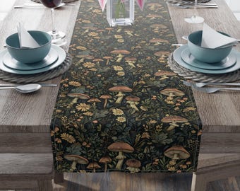 May include: A dark table runner with a botanical design featuring mushrooms, flowers, and foliage. The runner is placed on a wooden table set for a meal, with plates, bowls, and glasses visible.