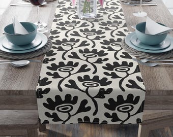 May include: Black and white floral table runner with a modern design. The runner is made of a soft, durable fabric and is perfect for adding a touch of style to any dining table.