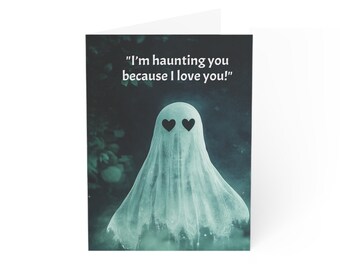 May include: A folded greeting card with a ghostly figure and heart-shaped eyes. The ghost is draped in a flowing white sheet against a dark, misty background. The card reads, "I'm haunting you because I love you!"