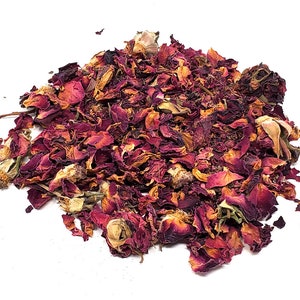 May include: A pile of dried rose petals, a mix of deep red and light pink, with some white buds still attached.