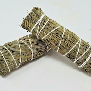 May include: Two bundles of dried sage smudge sticks tied with white twine. The sage is a light green color and the bundles are about 8 inches long.