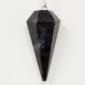 May include: A black crystal pendulum with a silver chain. The pendulum is shaped like a pointed teardrop.