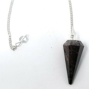 May include: A black crystal pendulum with a silver chain. The pendulum is shaped like a pointed cone and has a faceted surface.