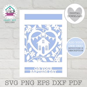 May include: A white paper-cut design on a light blue background featuring a central heart shape containing a church, bunting, flowers, and birds. The text "ON YOUR BAPTISM DAY" is at the bottom. Includes logos for Craft Hut Designs and digital download.