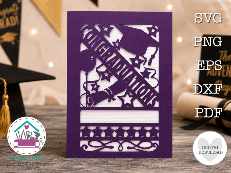 May include: A purple laser-cut greeting card featuring the word CONGRATULATIONS, a graduation cap, a diploma, stars, and a balloon. The design includes a horizontal band of stars and decorative swirls at the bottom, set against a white background.