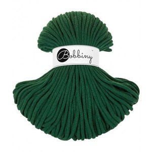 May include: A spool of dark green cotton cord, labelled "Bobbiny".