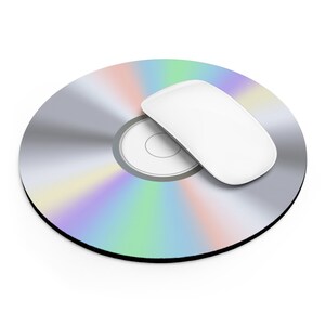 May include: A silver CD with a rainbow iridescent design and a white computer mouse on top.