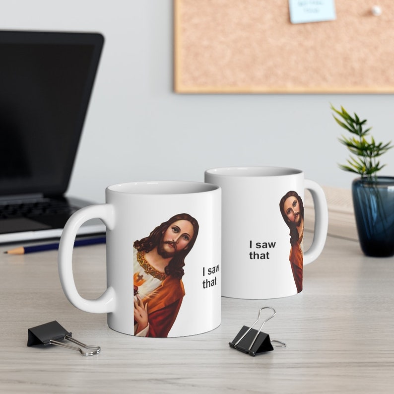 May include: Two white ceramic mugs with a humorous image of Jesus looking over his shoulder and the text "I saw that".
