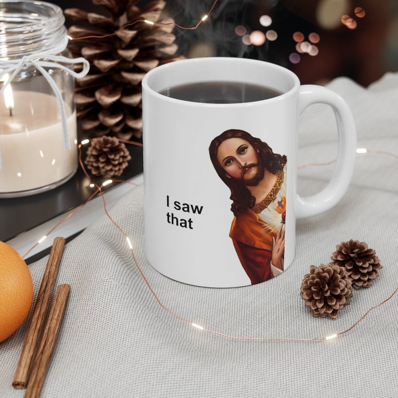 May include: White ceramic coffee mug with a picture of Jesus on it. The mug has the text "I saw that" printed on it.