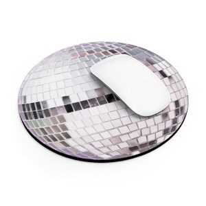 K&ouml;nnte beinhalten: Ein rundes, silbernes Discokugel-Mauspad mit einer wei&szlig;en Computermaus darauf.