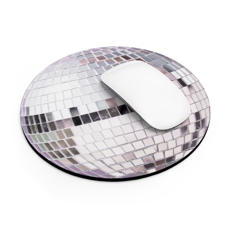 K&ouml;nnte beinhalten: Ein rundes, silbernes Discokugel-Mauspad mit einer wei&szlig;en Computermaus darauf.
