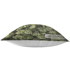 Peut inclure: Un coussin de d&eacute;coration vert et blanc avec un motif de feuilles de marijuana. Le coussin a une bordure blanche et le texte "Dank Odor Protection" en vert.